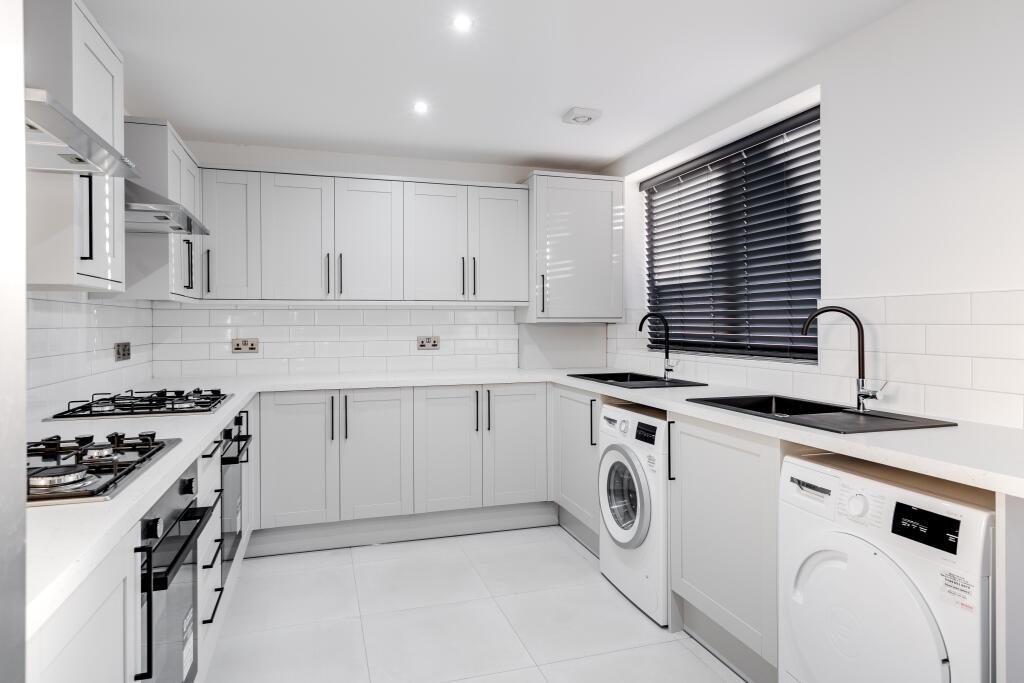 Modern and bright kitchen with ample white cabi...