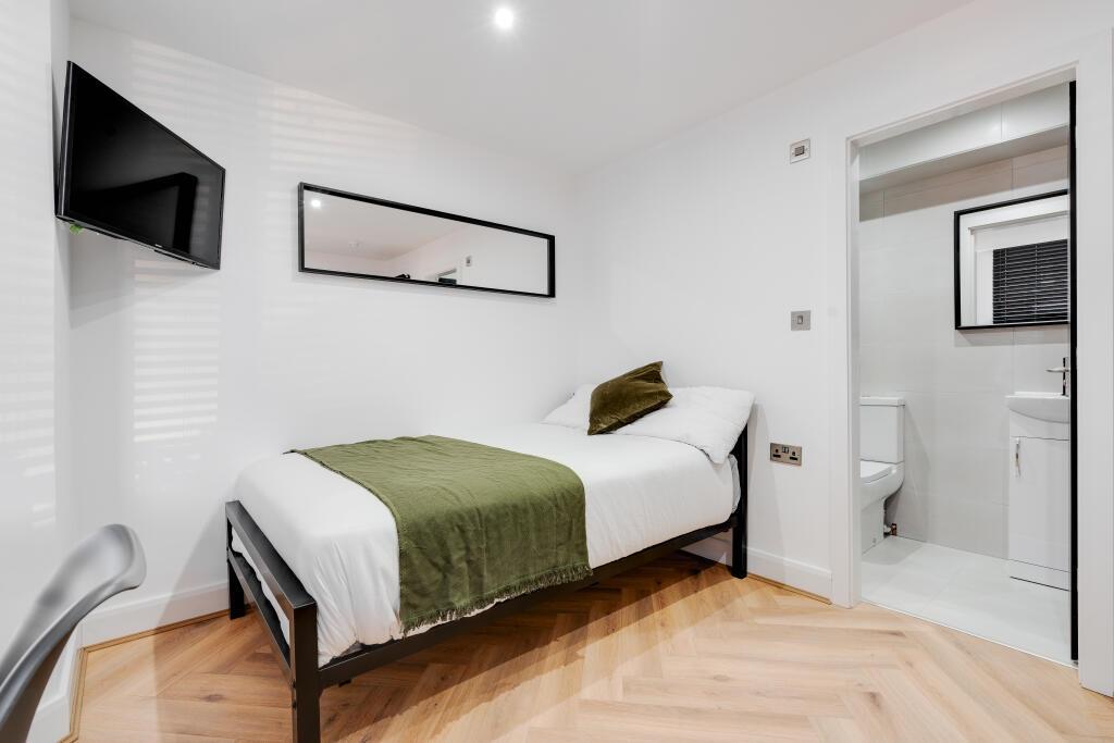 A bright and tidy single bedroom featuring a co...