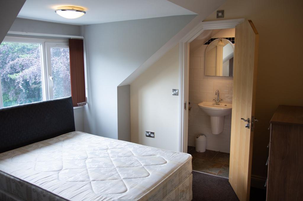 Bright and tidy bedroom featuring a large windo...