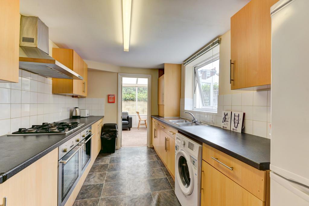Bright galley kitchen with modern appliances, a...