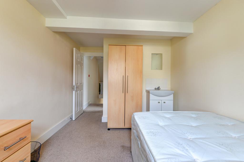 A tidy student bedroom featuring a double bed, ...