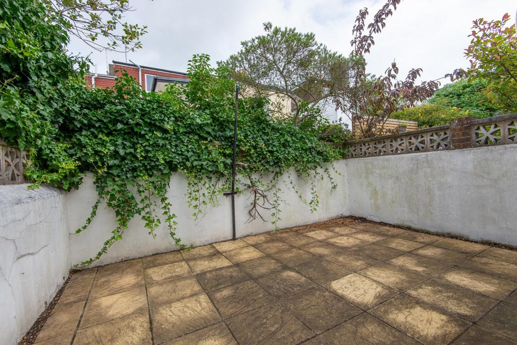 Private paved courtyard with leafy boundary, hi...