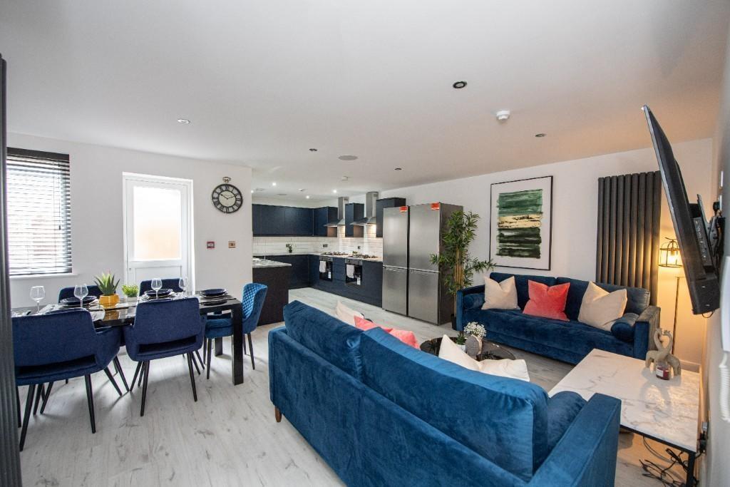 A spacious and modern living room featuring com...