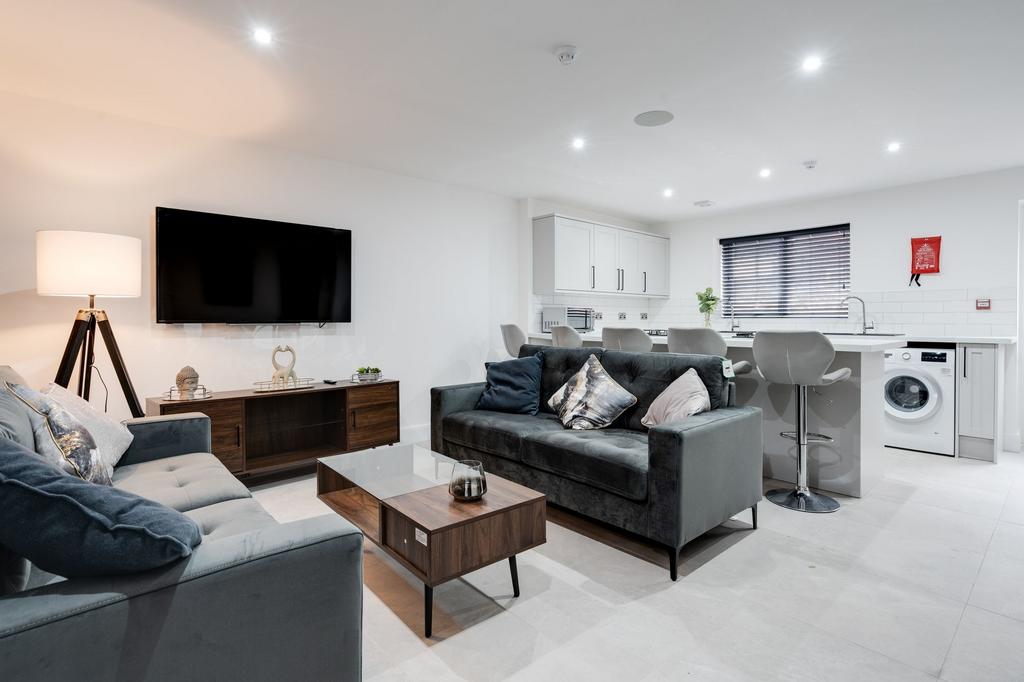 Bright and modern living room featuring two com...