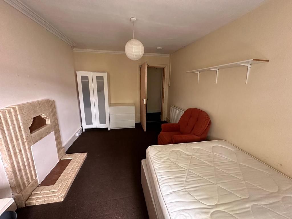Bright, long bedroom with neutral walls, fitted...