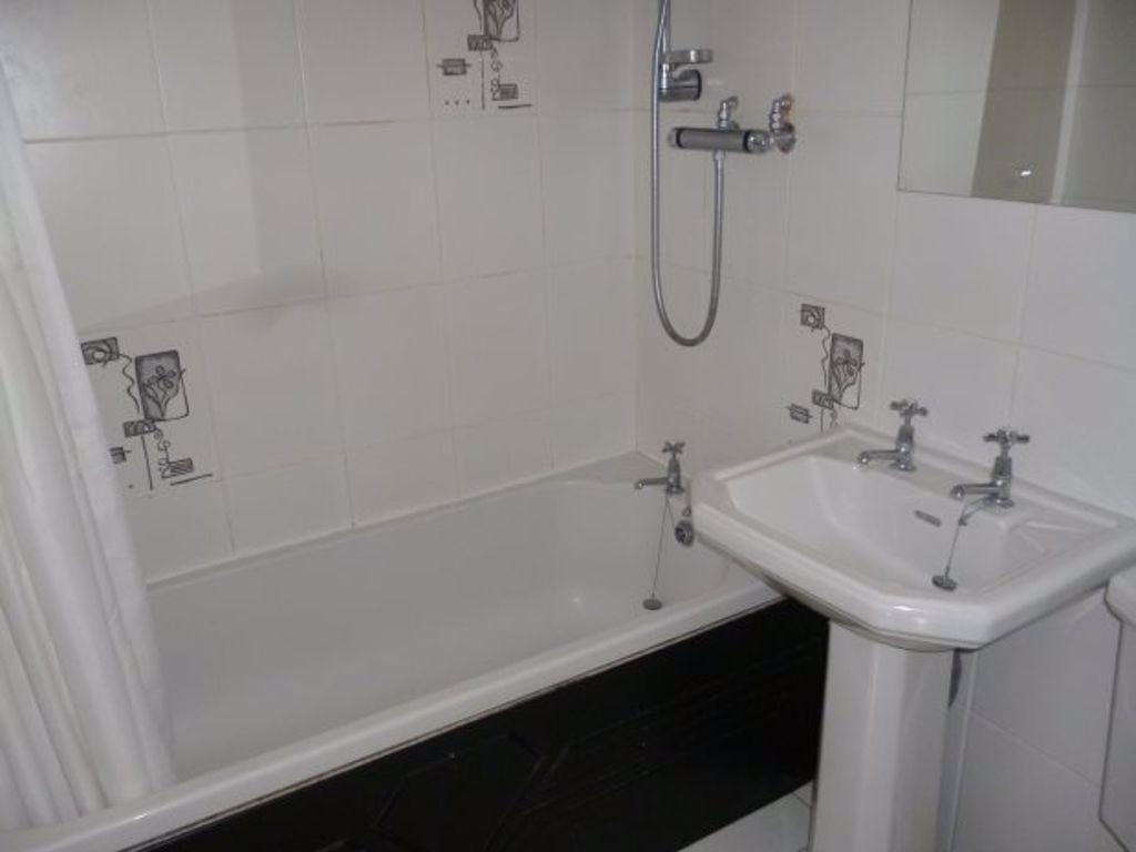 Well-maintained bathroom with a bath, overhead ...