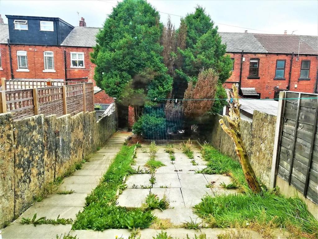 Rear garden with paved patio area, bordered by ...