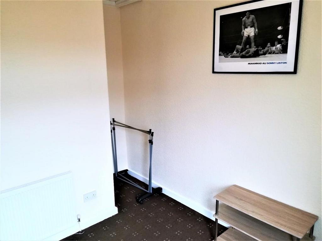 Simple single bedroom with neutral walls, fitte...