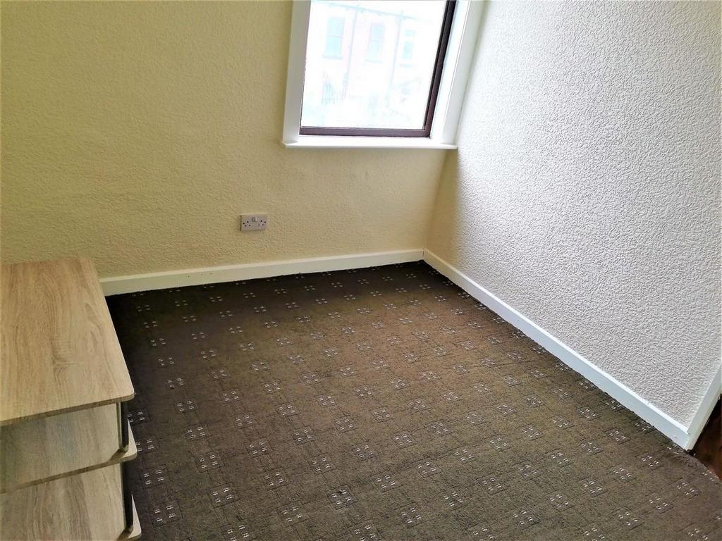 Compact furnished single bedroom with a corner ...