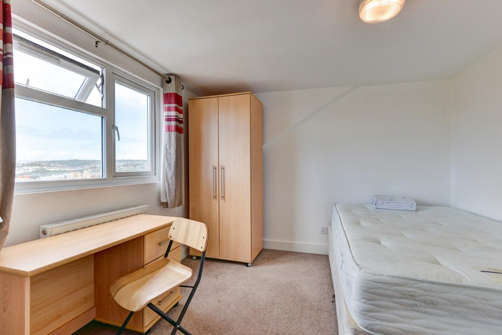 A tidy student bedroom featuring a single bed, ...