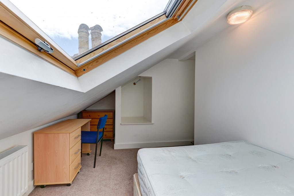 A cozy single bedroom with a sloped ceiling fea...