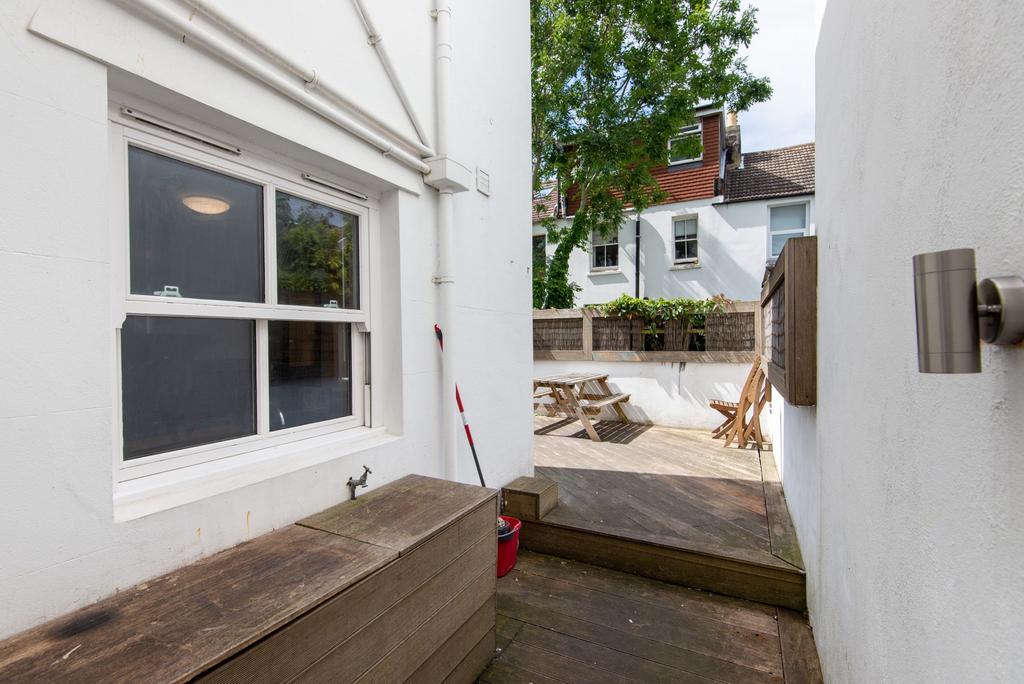 Private paved rear courtyard with raised timber...
