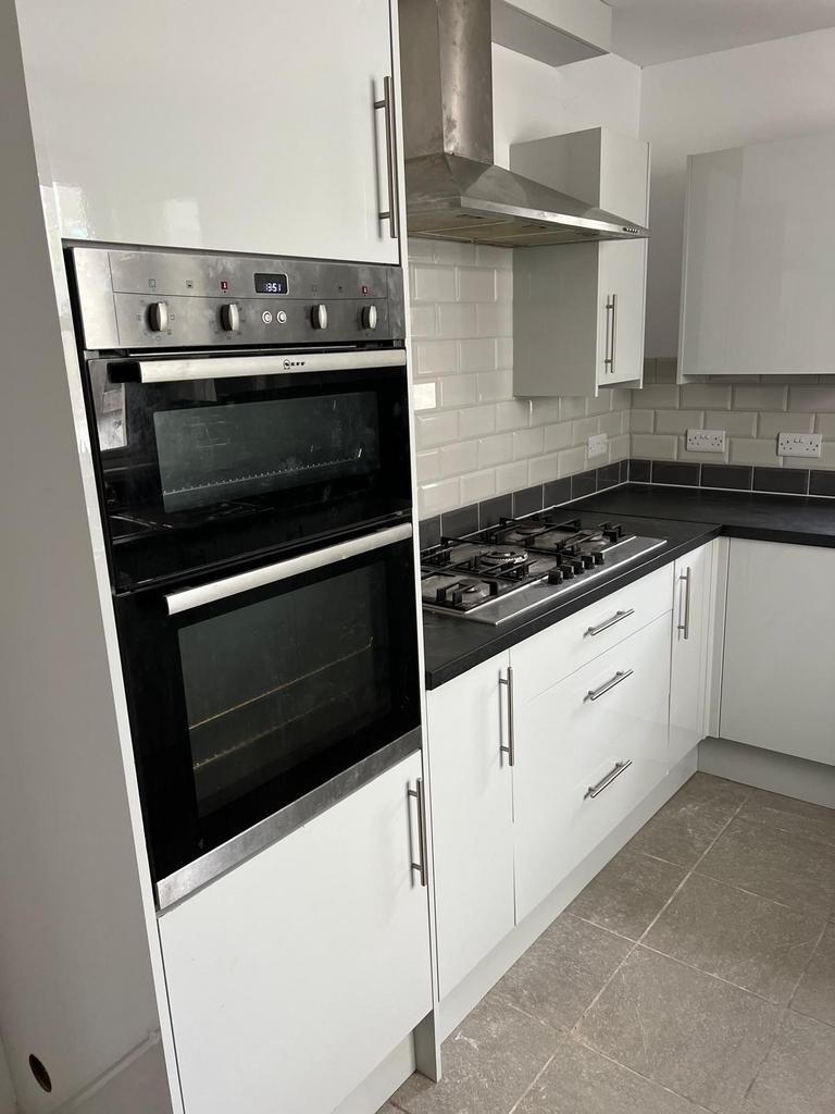 Modern fitted kitchen with white cabinets, inte...