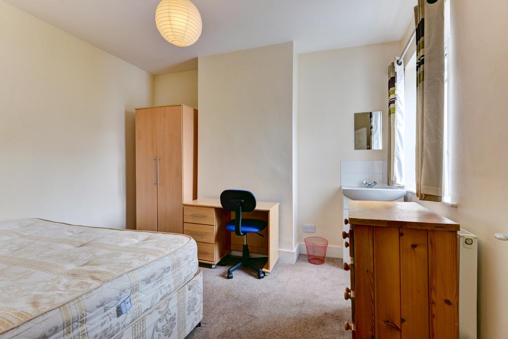 Bright, simply furnished bedroom with a double ...