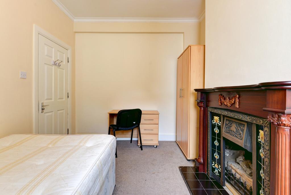 A cozy student bedroom featuring a comfortable ...