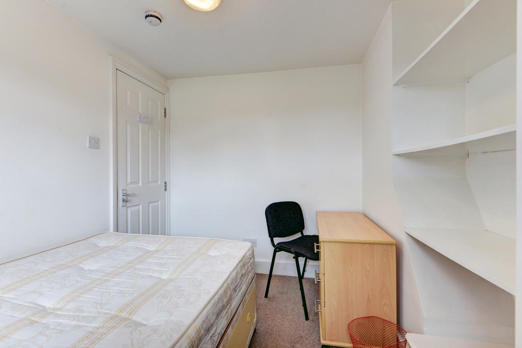 Bright, simply furnished bedroom with a bed, de...