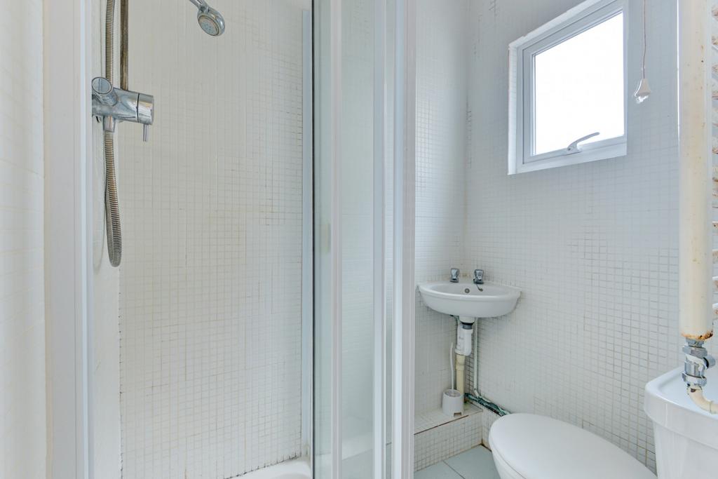 Bright, neatly presented bathroom with an enclo...