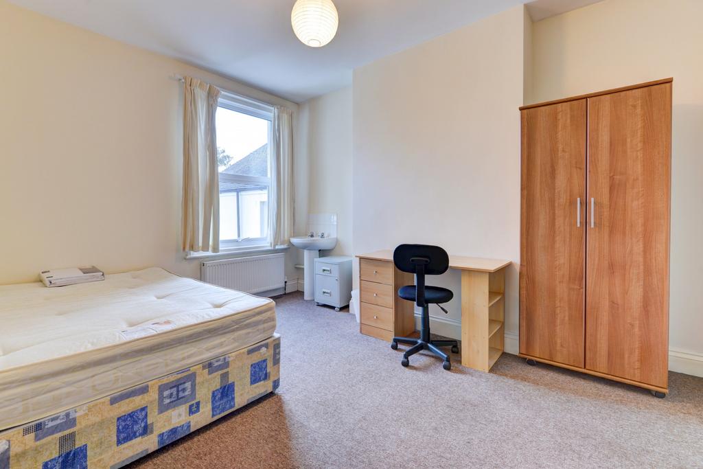 A bright, tidy bedroom featuring a double bed, ...
