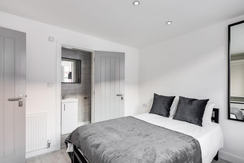 A modern, well-lit bedroom featuring a large do...