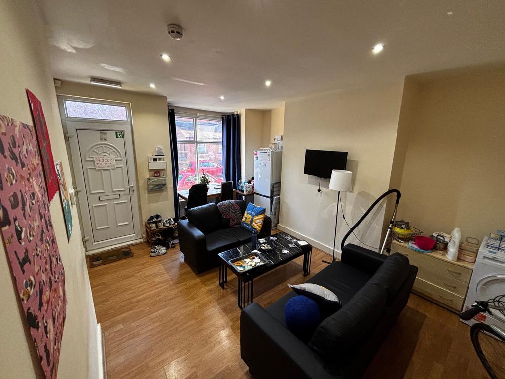 Well-lit communal living area with two black so...