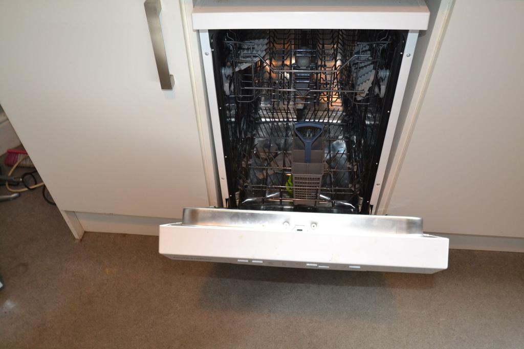 A modern built-in dishwasher with the door open...