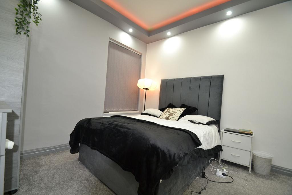 Stylish double bedroom with a tall upholstered ...
