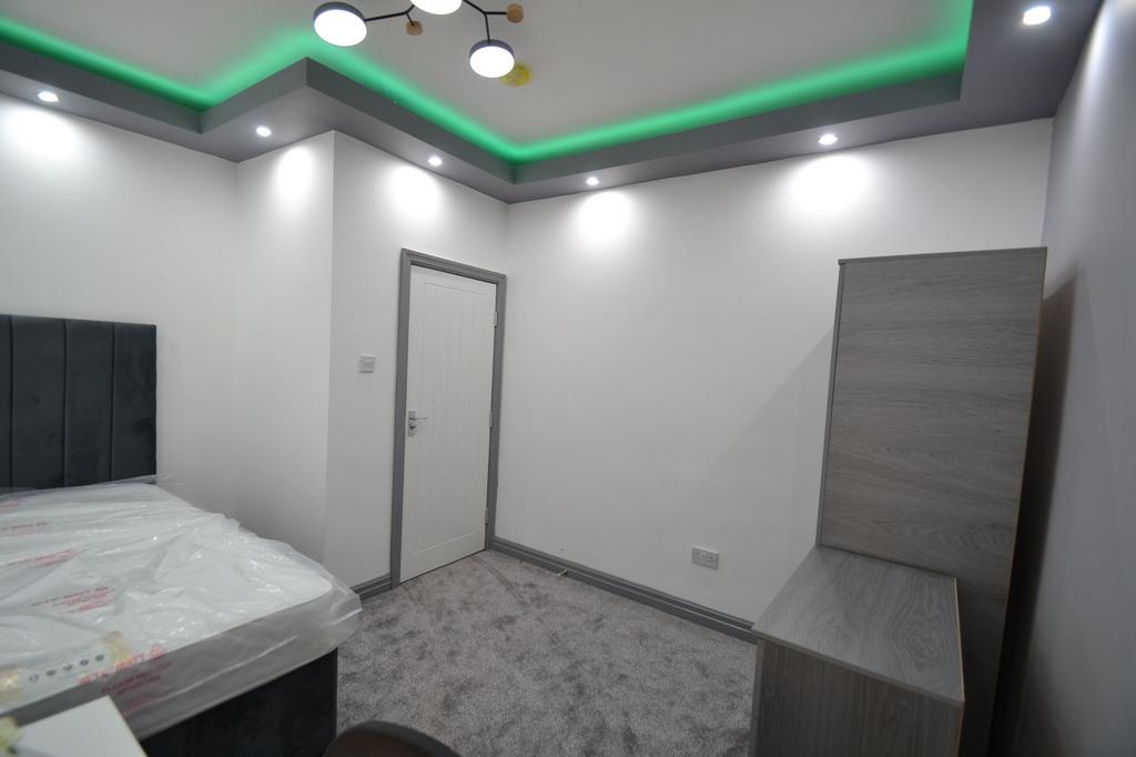 A modern bedroom with crisp white walls, a styl...