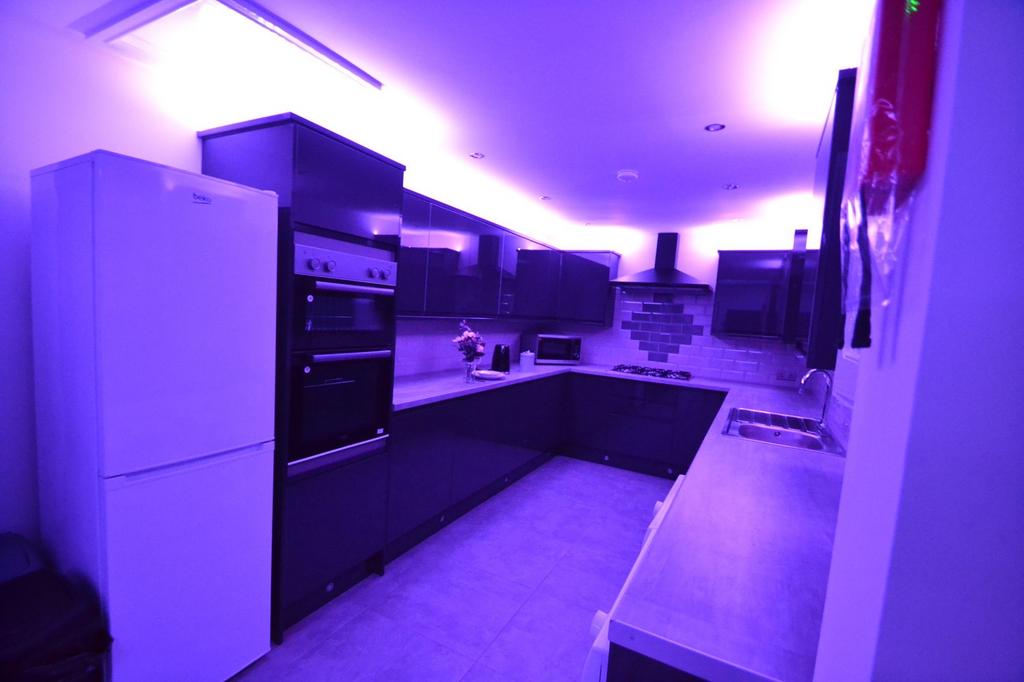Modern kitchen illuminated with vibrant purple ...