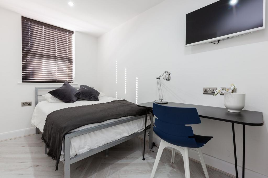A modern, tidy bedroom featuring a comfortable ...