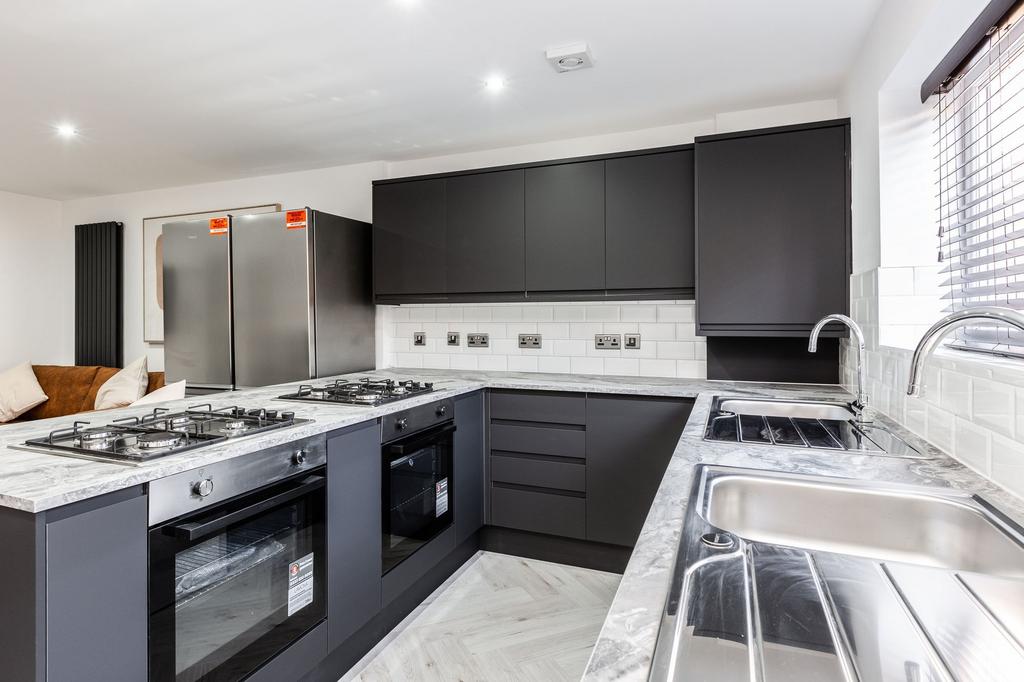 Modern kitchen featuring sleek dark cabinetry, ...