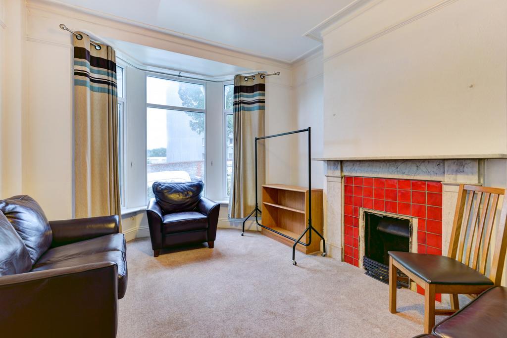 Bright living room with a bay window letting in...