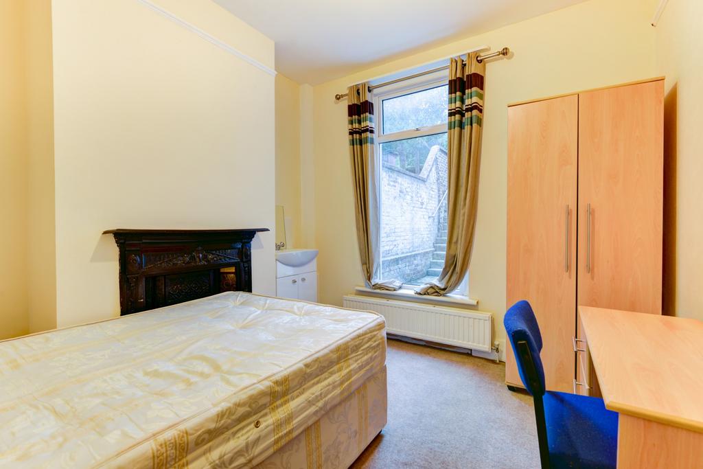 Bright, furnished bedroom with a double bed, wa...