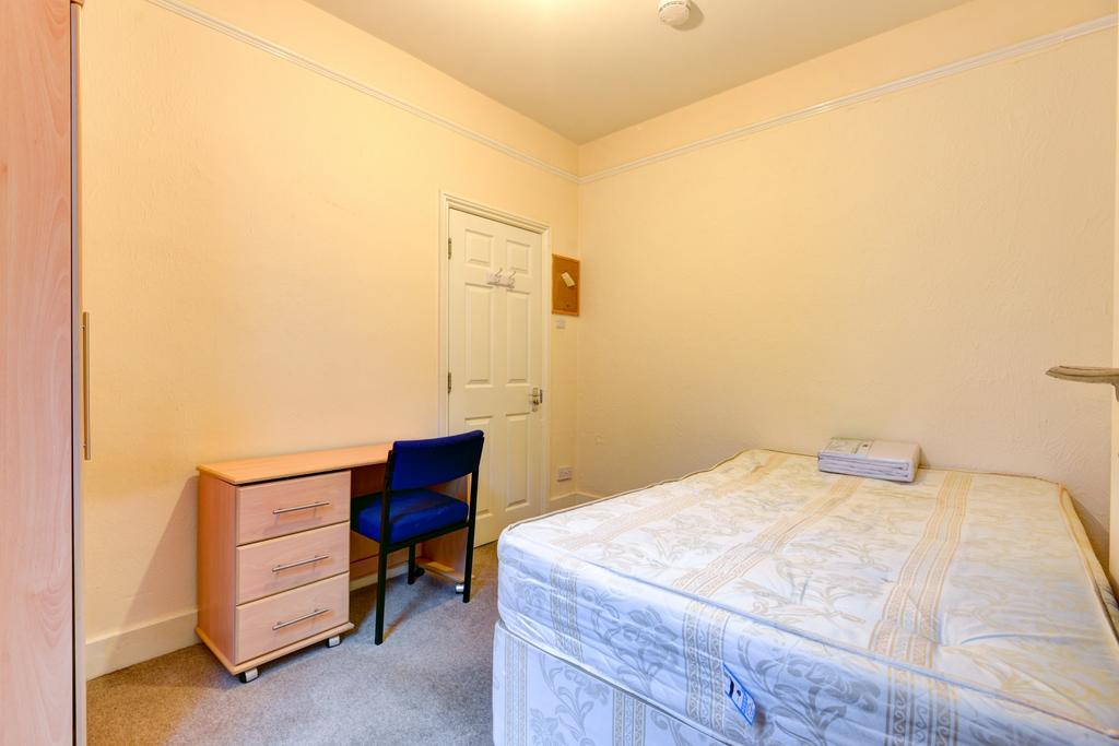 Bright, simply furnished bedroom with a comfort...