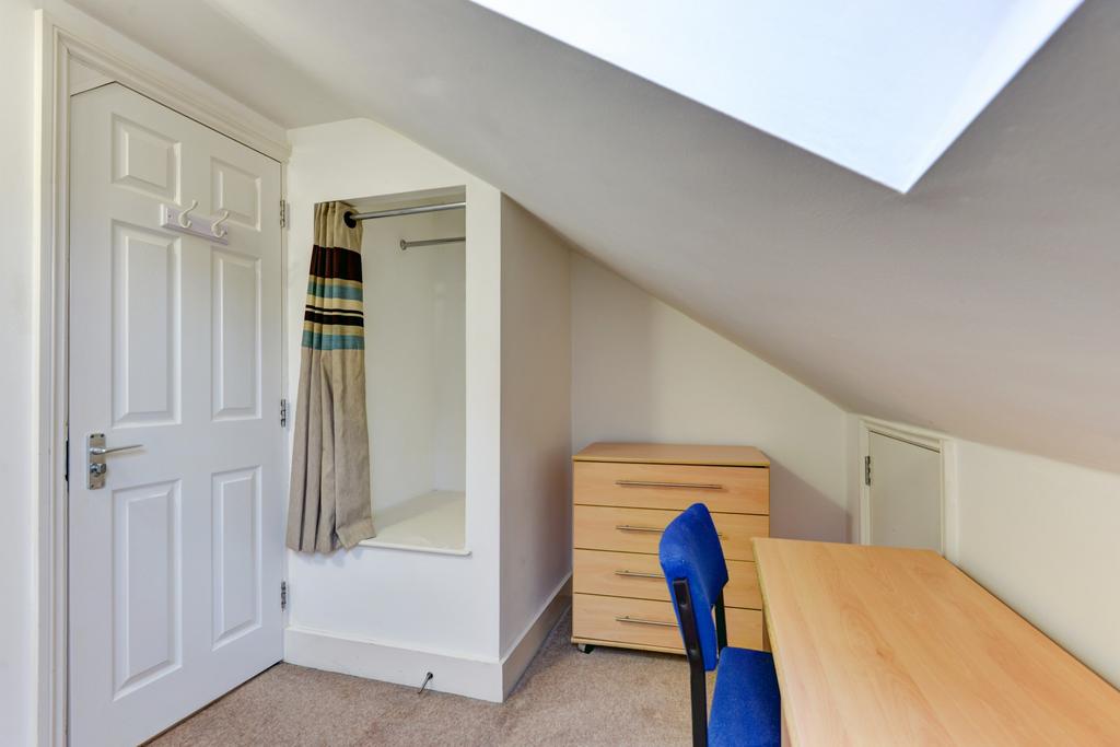 Bright attic single bedroom with a large skylig...