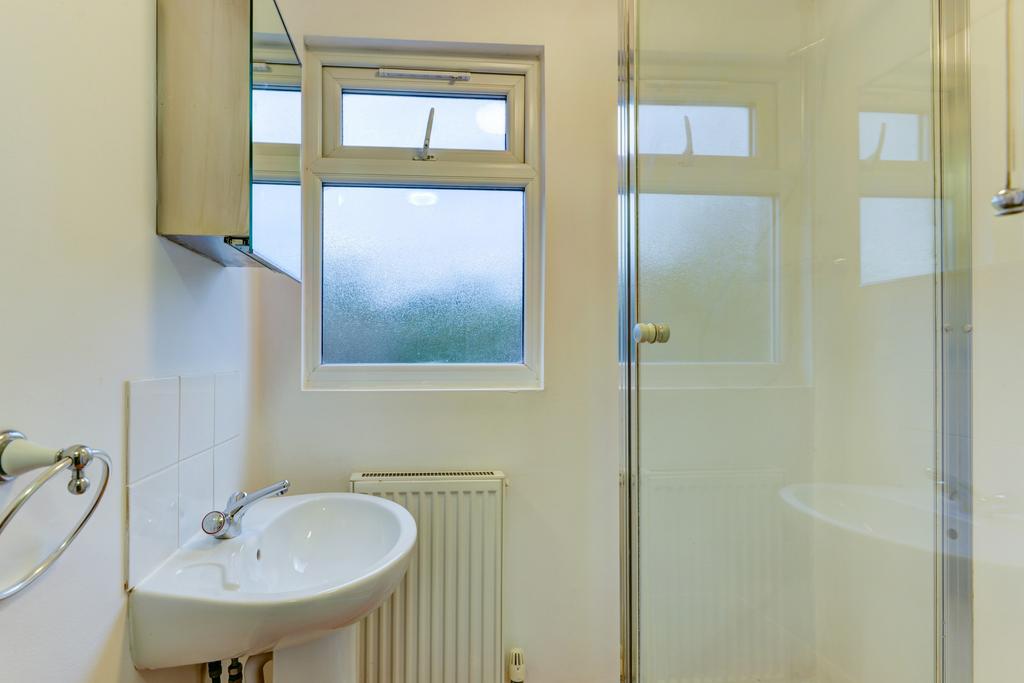 Bright, clean bathroom with a pedestal sink, fr...