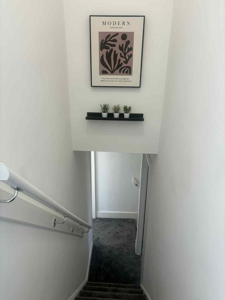 A modern staircase with a white wall adorned wi...