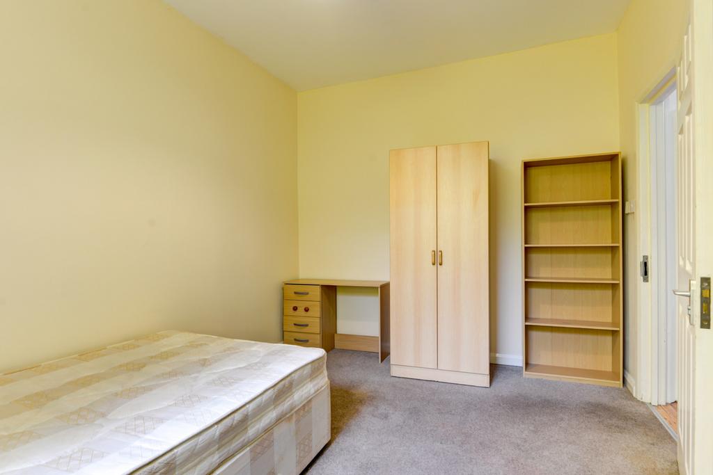 Bright, simply furnished bedroom with neutral d...