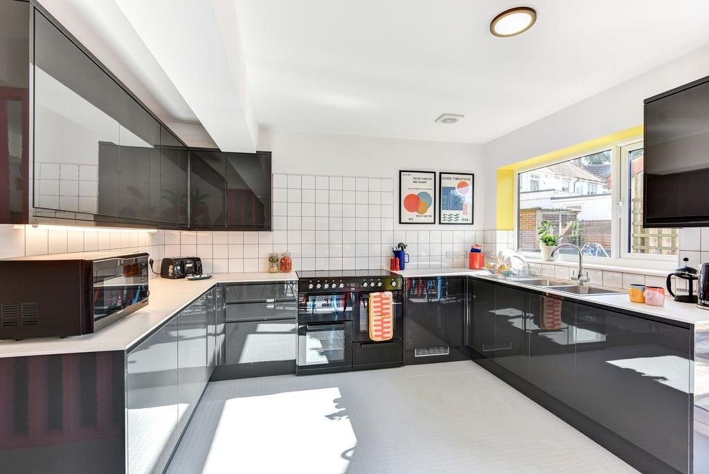 A modern, spacious kitchen featuring sleek blac...