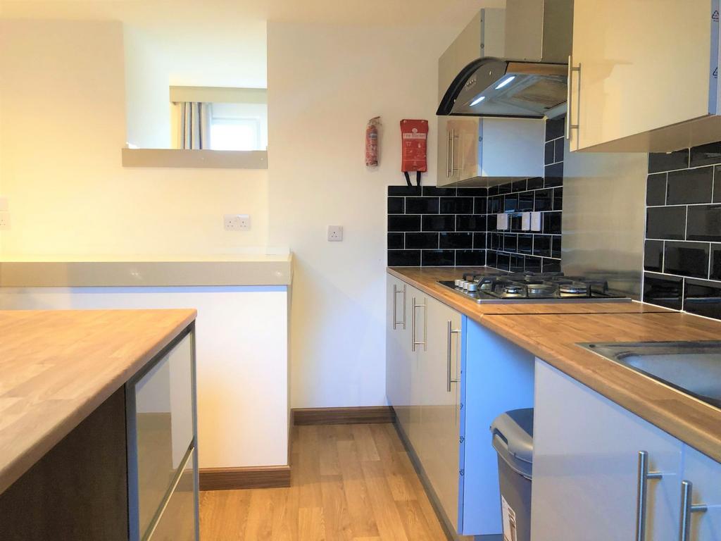 A modern kitchen with sleek black tiled splashb...