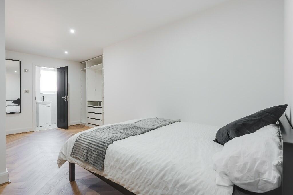 A bright and modern bedroom featuring a comfort...