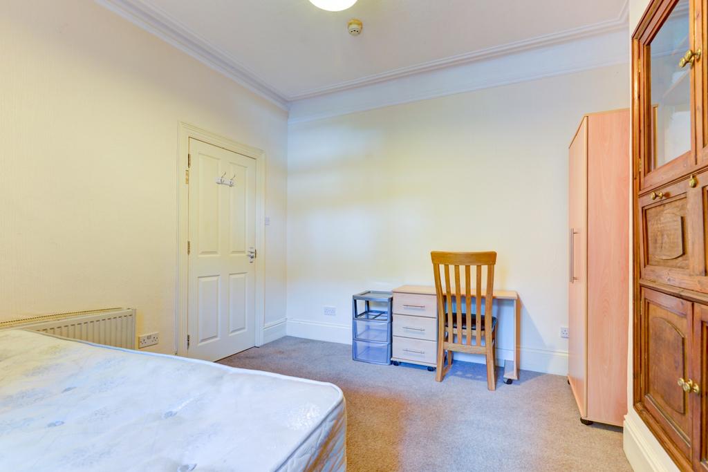 Bright and tidy single bedroom featuring a wood...