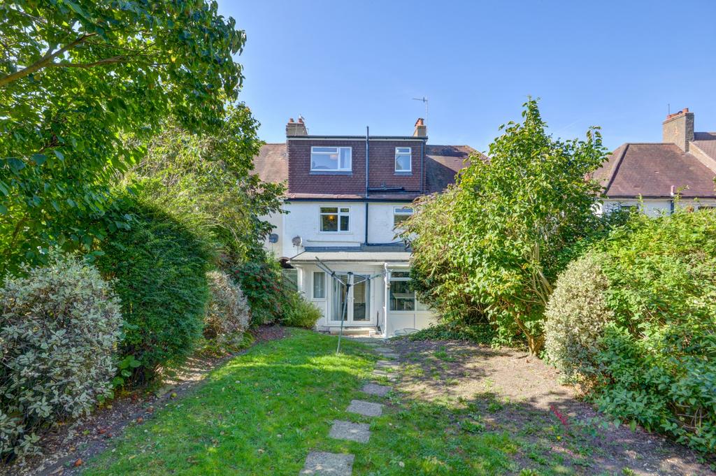 Sunny private rear garden with a paved path lea...