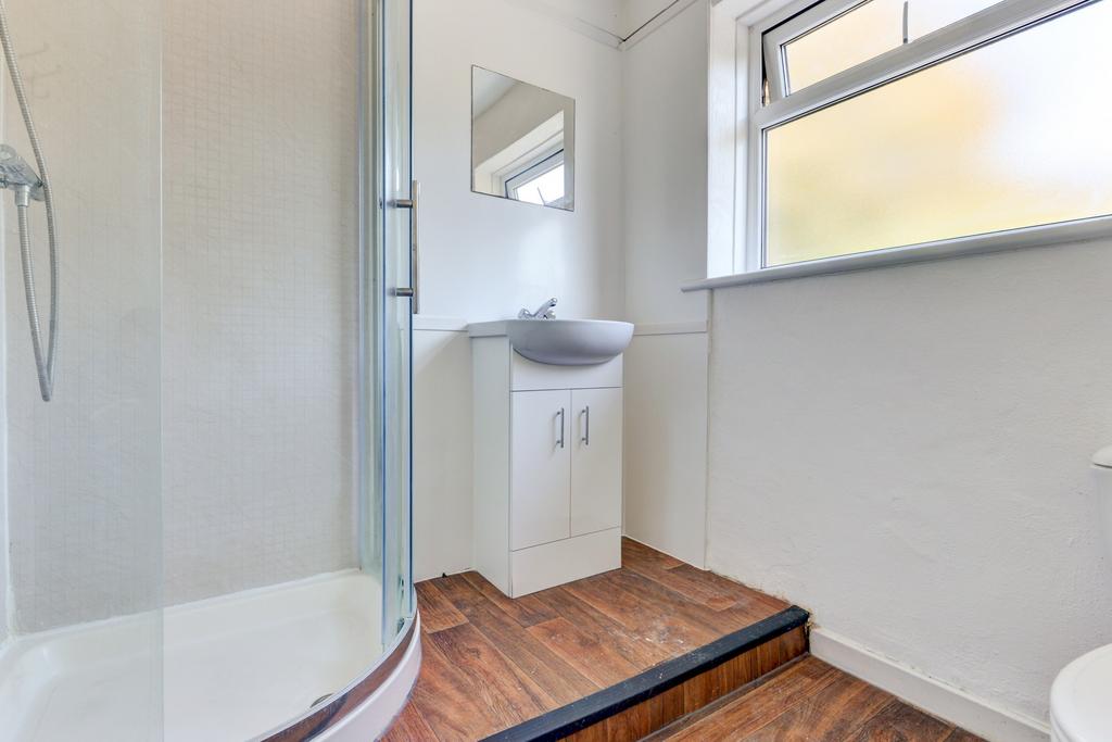 Bright, modern bathroom featuring a corner show...