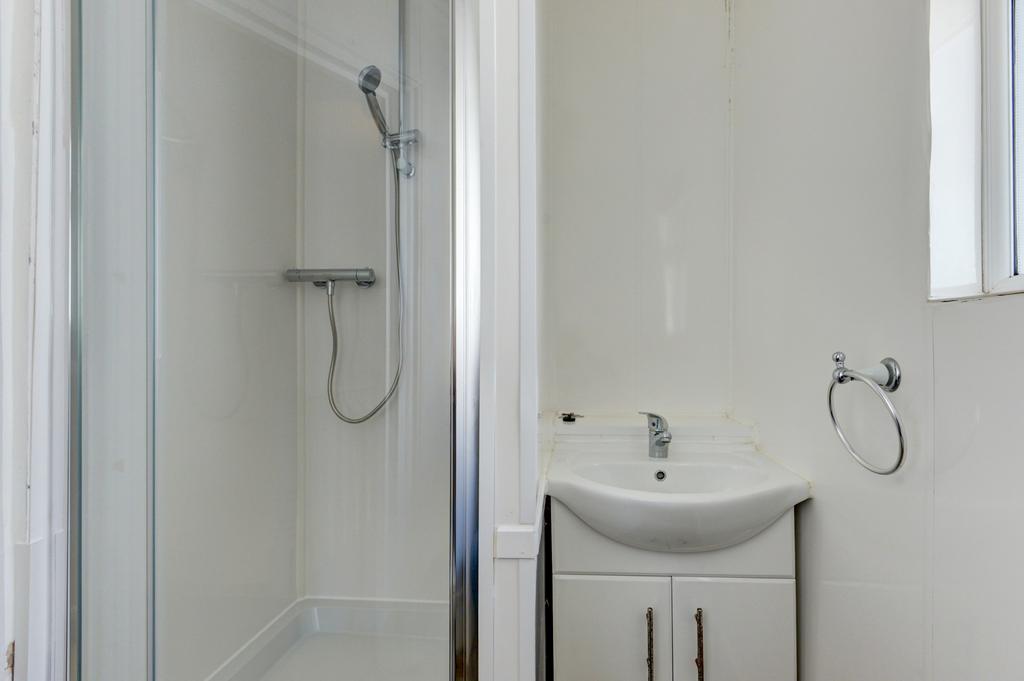 A clean and functional bathroom featuring a sho...