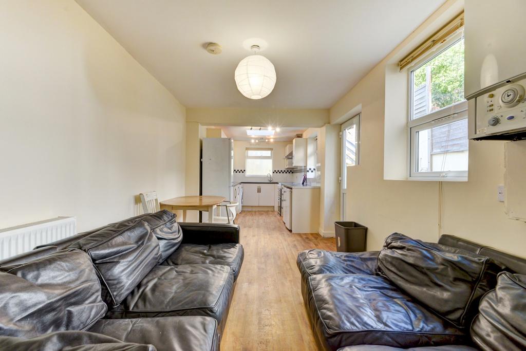 Bright open-plan living area with seating, wood...