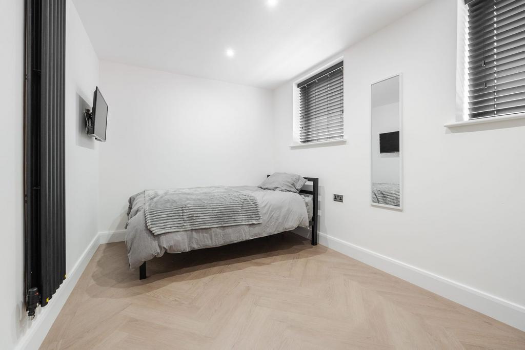 A bright and modern single bedroom featuring mi...