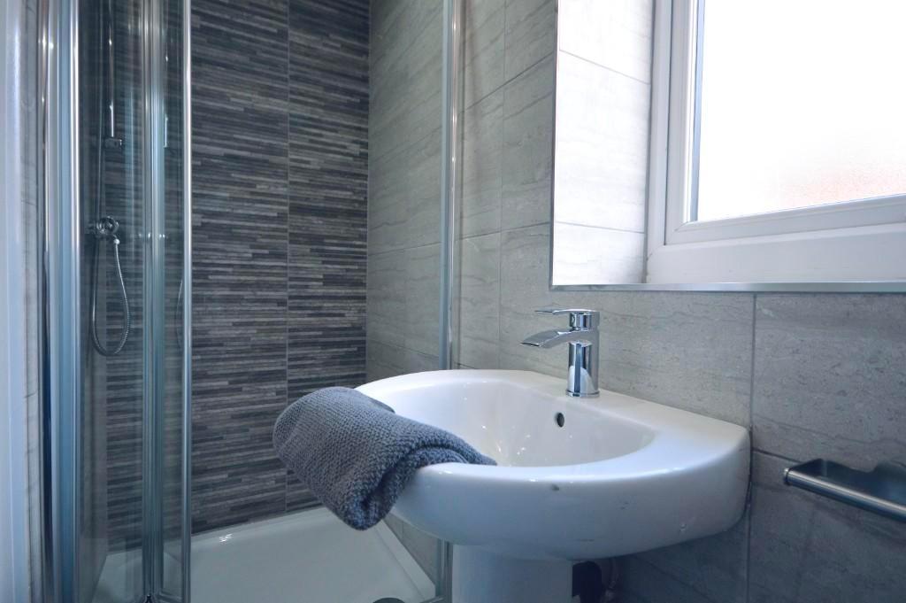 A clean and bright bathroom with a large sink a...