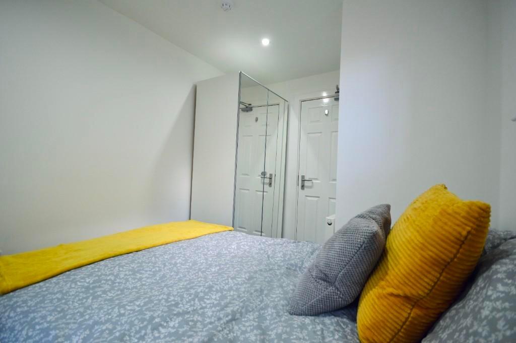 A bright and tidy bedroom featuring a comfortab...
