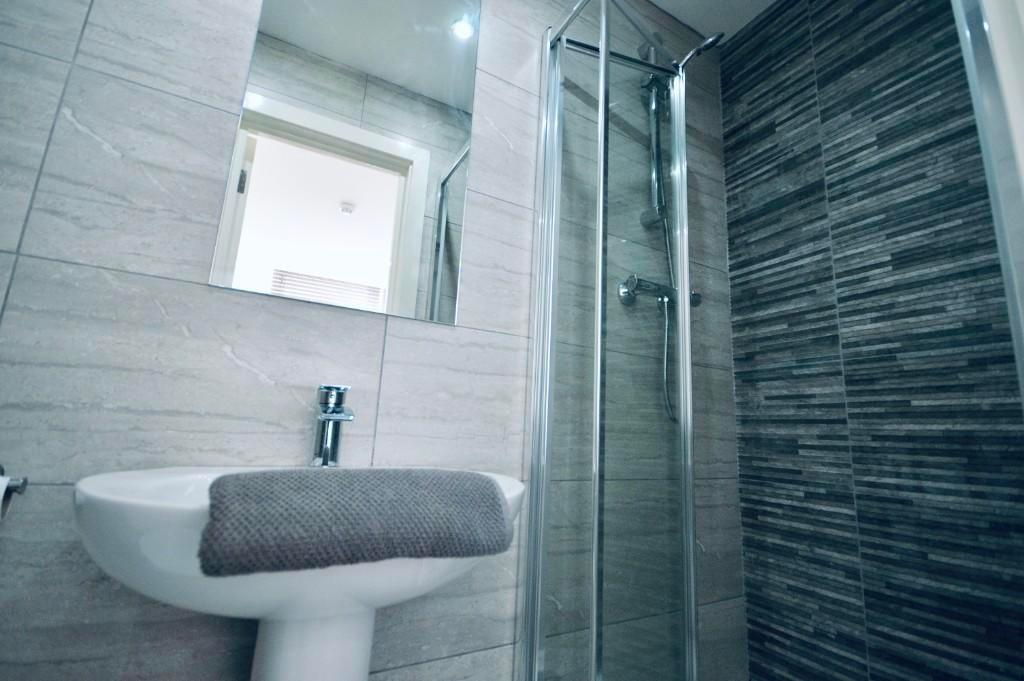 A modern bathroom featuring a large shower area...