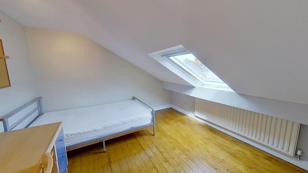 Bright attic single bedroom with a sloped ceili...